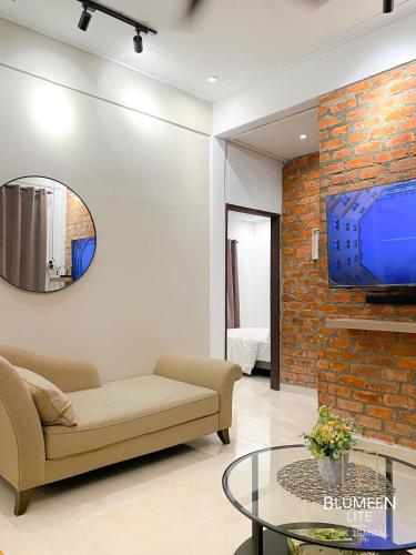 瓜拉丁加奴Blumeen Lite 1 - Comfortable Budget Home 3BR的客厅配有沙发和砖墙电视