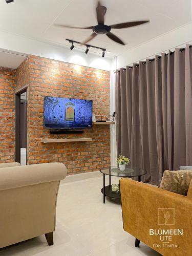 瓜拉丁加奴Blumeen Lite 1 - Comfortable Budget Home 3BR的客厅配有沙发和砖墙电视