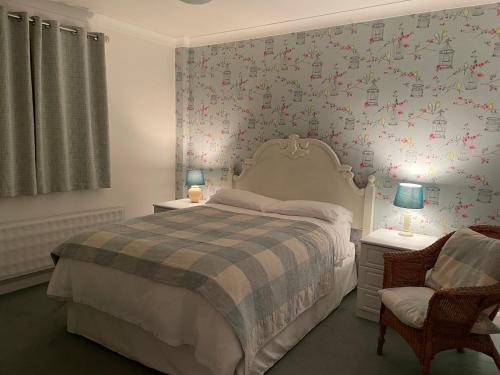 米尔登霍尔Silver Lodge Guest House的一间卧室设有一张床和鲜花墙