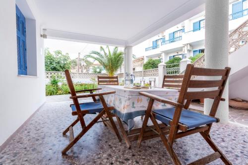 斯卡拉埃雷索La Skala Eressos Holiday Apartments的庭院配有两把椅子和一张桌子