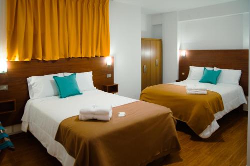 奥克萨潘帕La Posada D'Benjamín的酒店客房带两张带黄色和蓝色枕头的床