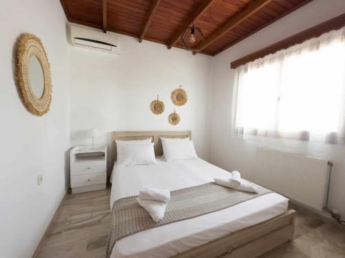 KámposVilla Aelia的一间卧室配有一张带白色床单的床和一扇窗户。