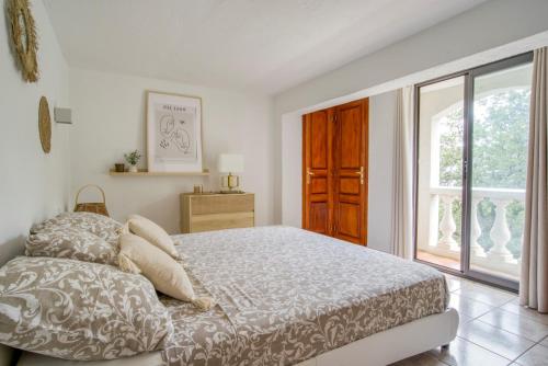 卡罗CHARMANT 2 PIECES DANS VILLA INDIVIDUELLE TERRASSES JARDIN的白色的卧室设有床和窗户