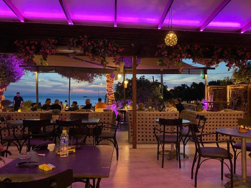 阿纳维索斯me gusta suite by the sea的餐厅拥有紫色的灯光,人们坐在桌子上