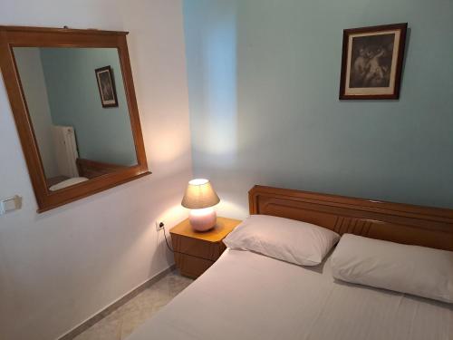纳弗帕克托斯NAFPAKTOS old town的一间卧室配有一张带镜子和灯的床