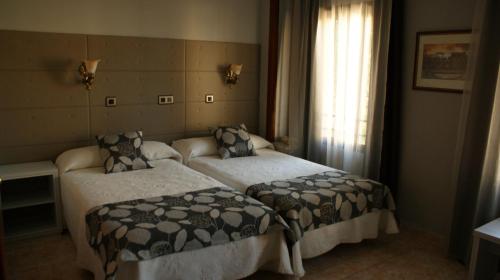 卡塞雷斯洛斯那然约斯酒店的酒店客房设有两张床和窗户。