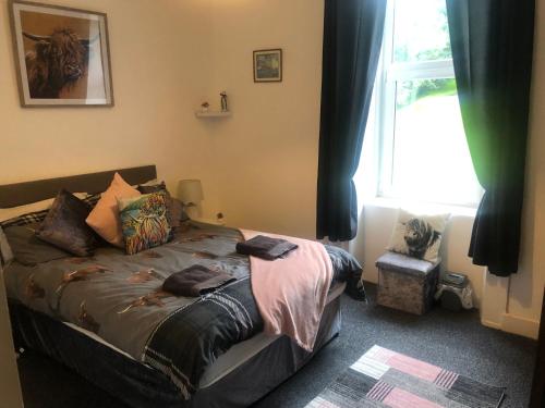 罗撒西Captivating 2-Bed Apartment in Isle of Bute的一间卧室设有一张带窗户和窗户的床。