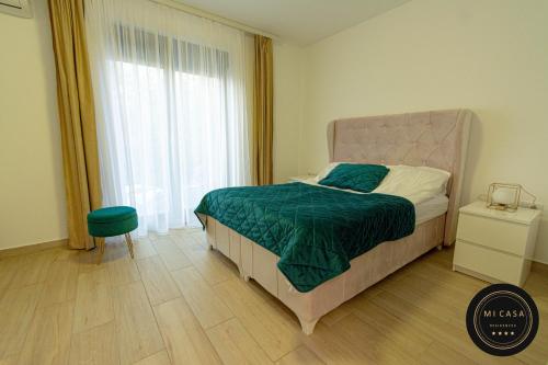 维尔蒂尼克Mi Casa 2的一间卧室配有一张带绿毯的床和窗户。