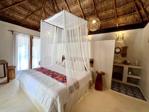 图卢姆Lodge Tzunum Jade的一间卧室配有一张带天蓬的床