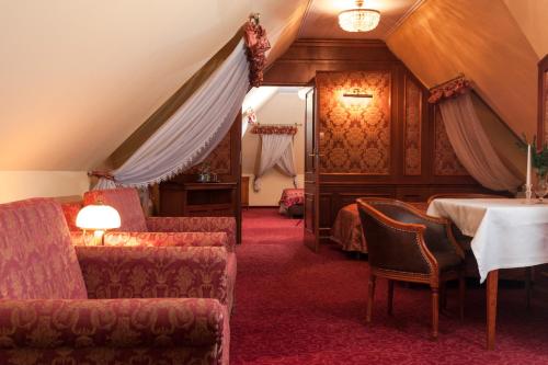 桑多梅日科罗纳酒店的酒店客房带一张床、一张桌子和椅子
