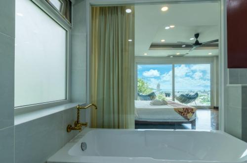 芭东海滩seaview patong private pool sauna 4br villa的带浴缸的浴室和窗户