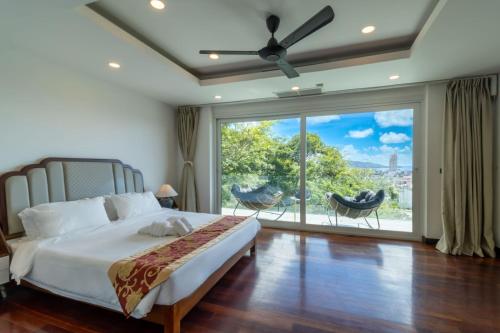 芭东海滩seaview patong private pool sauna 4br villa的一间卧室设有一张床和一个大窗户