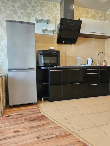 第聂伯罗Most City Riverview的厨房配有冰箱和微波炉。