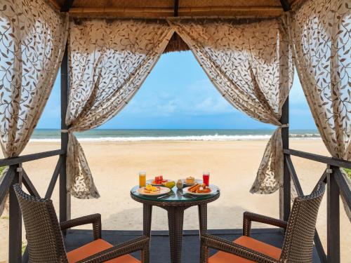 UtordaITC Grand Goa, a Luxury Collection Resort & Spa, Goa的海滩上的桌椅