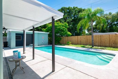 坦帕Perfect Pool Home for Family Getaway Close to Tampa Zoo, Busch Gardens, Restaurants and Shopping!的院子中游泳池上方的白色天篷