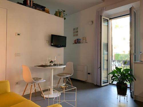 梅纳焦Villa Paola - Holiday Apartment - Menaggio, Lago di Como的客厅配有桌椅和电视。