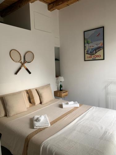 梅纳焦Villa Paola - Holiday Apartment - Menaggio, Lago di Como的卧室配有一张大床,墙上挂着一个球拍