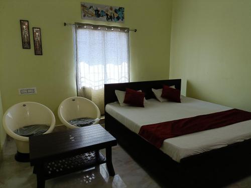 王舍城Hotel Narayani的一间卧室设有两张床、一张桌子和一个窗口