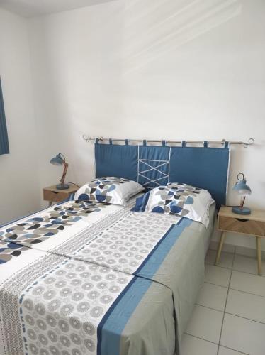 库鲁La Coraline Standing的一张蓝色和白色的床,配有两个枕头