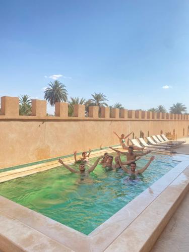 梅尔祖卡Desert Villa Boutique Hotel Merzouga的一群人在游泳池里