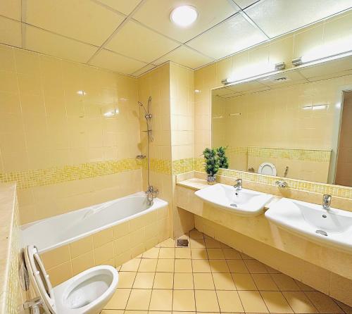 迪拜VIP Hostel - Females Only的一间带两个盥洗盆、浴缸和卫生间的浴室
