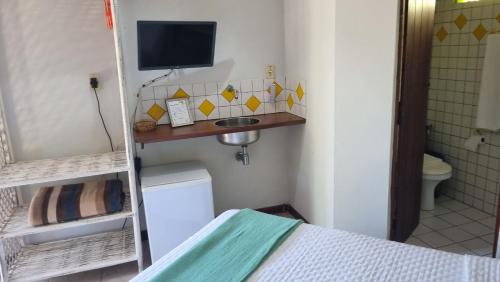 普拉亚多旗鱼旅馆的小房间设有床铺和电视