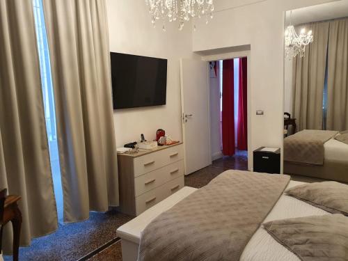瓦拉泽Varazze Suite Sauna e Hammam的一间卧室设有两张床,墙上配有电视。