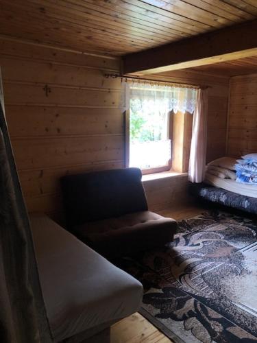 SólStara chałpa oźna的小木屋内的一个房间,配有沙发和窗户