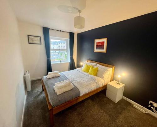 奥本16 Macgregor court, Oban的一间卧室配有一张带黄色枕头的床和一扇窗户