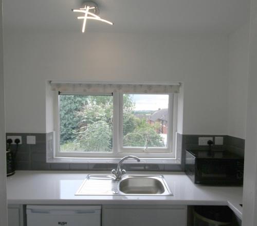 GreenhillSheffield serviced apartment的厨房设有水槽和窗户。