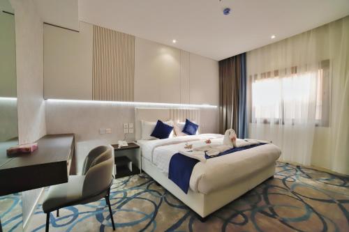 麦地那فندق زوايا الماسية(العوالي)的酒店客房设有一张大床、一张桌子和椅子。