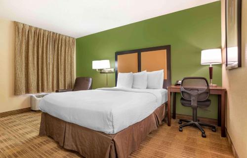 杰克逊Extended Stay America Select Suites - Jackson - North的酒店客房设有一张大床和一张书桌。