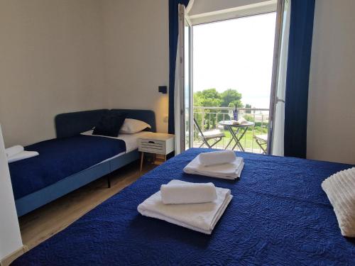 格拉达茨Apartment Ana - Gradac的一间卧室配有两张带毛巾的床和一个阳台
