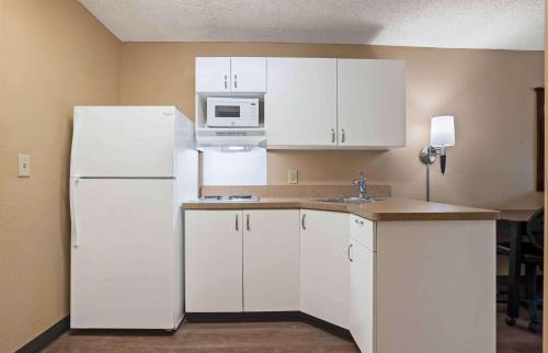 圣地亚哥圣地亚哥酒店圈美国长住酒店的厨房配有白色橱柜和白色冰箱。
