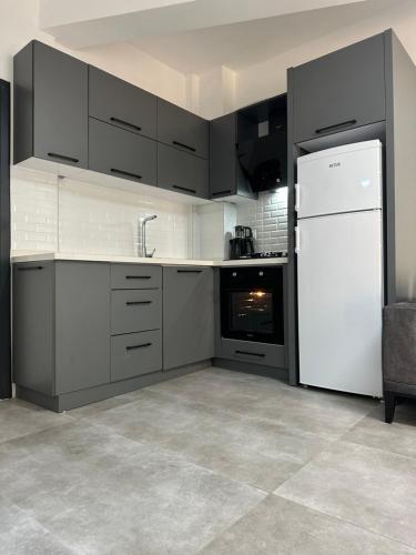 安塔利亚Suite64 Apartments的厨房配有白色冰箱和黑色橱柜。