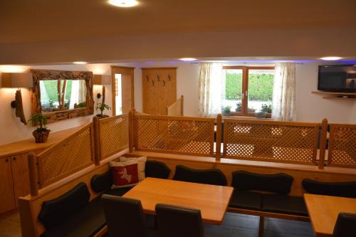 滨湖采尔米兰旅馆的一间带桌椅和电视的用餐室