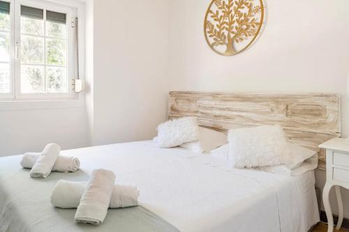 里斯本Cozy Haven Retreat的白色卧室配有白色床和毛巾
