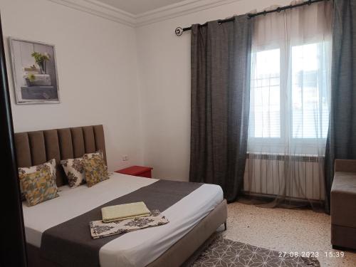 莫纳斯提尔Fufa Apartment的一间卧室设有一张大床和一个窗户。