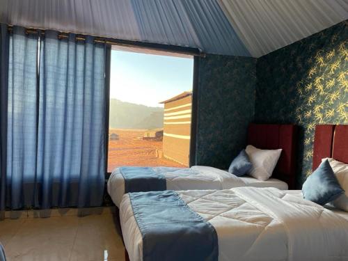 瓦迪拉姆超越瓦迪朗姆露营地的一间卧室设有两张床和大窗户