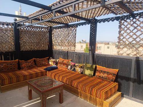 马拉喀什Dar Suncial的阳台的天井配有2张沙发和1张桌子