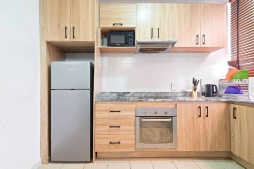 拉各斯OlliebeierArtApartment Charming recently refurbished three-bedroom apartment located in VI的厨房配有白色冰箱和木制橱柜。