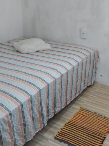 SaubaraCasa laranja cabuçu的一张带条纹毯子的床和枕头