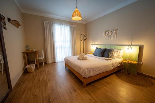 帕拉卡斯Viajero-Kokopelli Paracas Hostel的一间卧室设有一张大床,铺有木地板