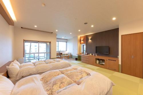 函馆新叶亭竹叶日式旅馆的大房间设有一排白色的床