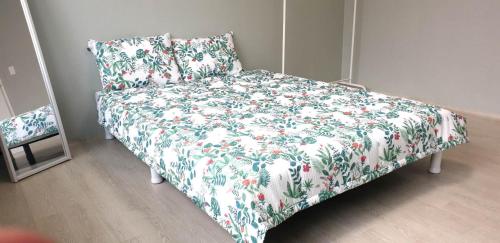 全州市Elle House的一张带鲜花毯子和枕头的床