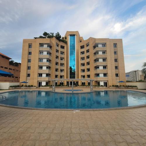 波拉马尔Apartamento Deluxe Isla Margarita - Costa Azul的一座大型建筑,前面设有一个大型游泳池