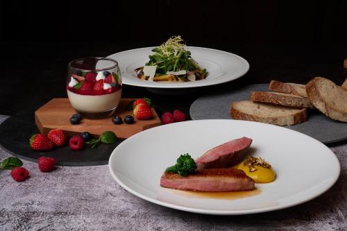 曼谷曼谷苏坤喜来登豪华精选大酒店的桌上的两盘食物,包括面包和草莓