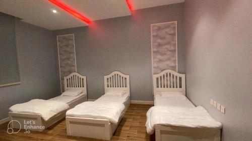 Yanbu Al Bahrشاليه العماريه的一间设有三张床和红灯的房间
