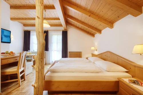 拉伊翁阿尔平风格酒店的一间卧室配有一张大床、一张桌子和一张四柱床。