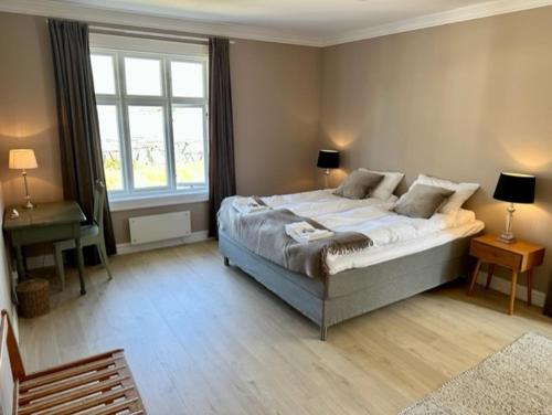 雷讷Det Gamle Hotellet Guesthouse的一间卧室设有一张大床和一个窗户。